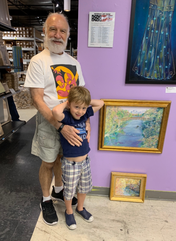 Adan & grandson at Jerry’s Artarama 2019 U.S. Veteran’s Art Show Reception w/his two replacement paintings that sold that night