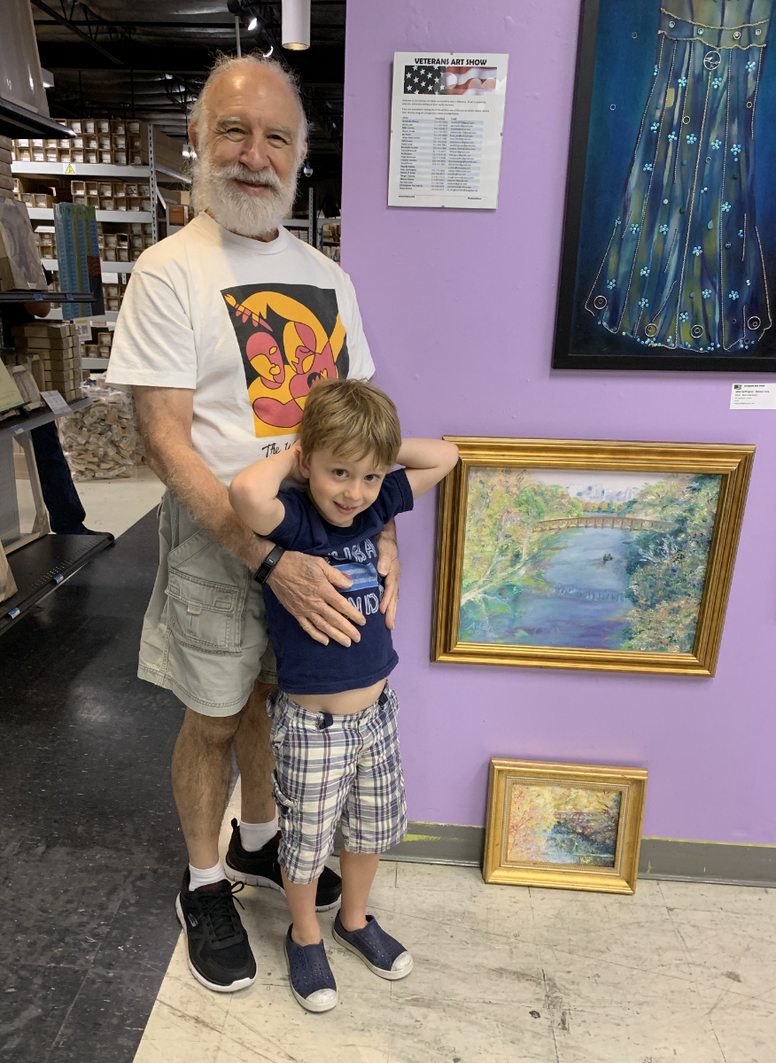 Adan & grandson at Jerry’s Artarama 2019 U.S. Veteran’s Art Show Reception w/his two replacement paintings that sold that night